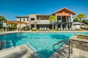 A swimming pool in front of a house with a pool